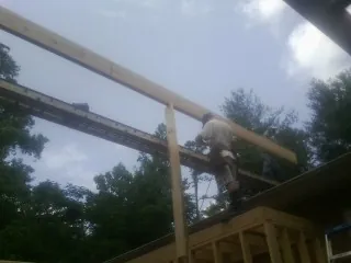 Carpenter setting a ridge beam over a new addition frame — Ice Dam Removal by Roofing Brothers in Rockport